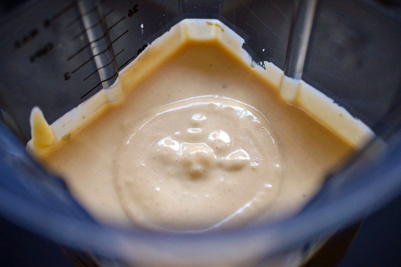 An overhead shot of a open blender container filled with creamy and keto Tonnato Sauce 