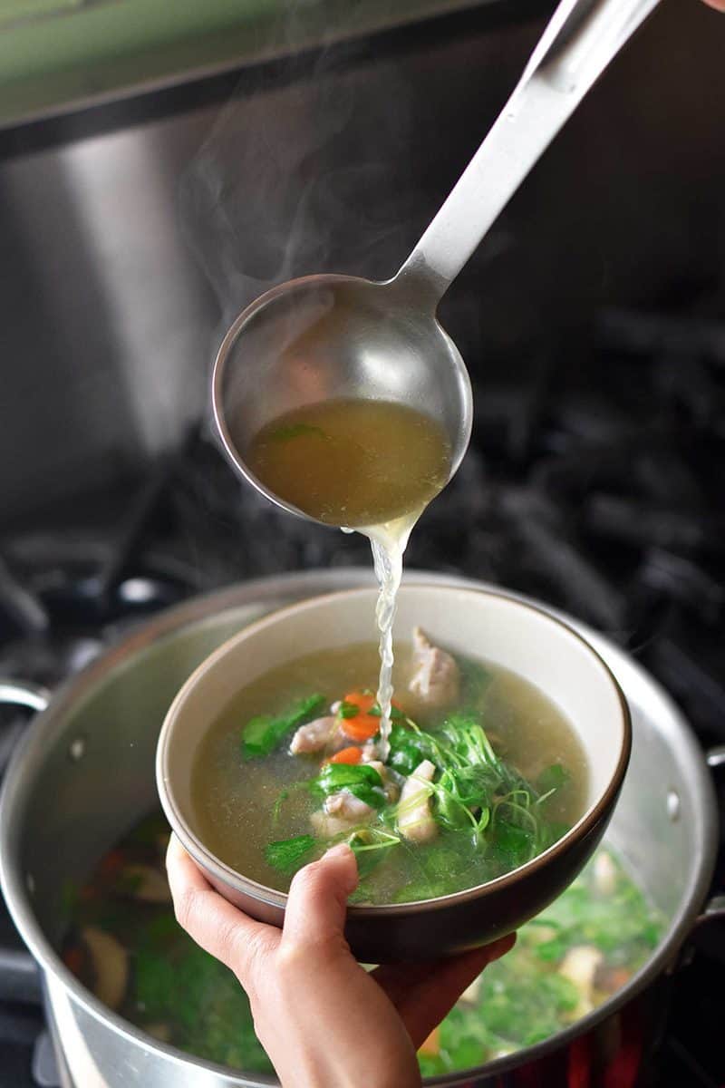 Ladling Watercress & Chicken Soup into a bowl.