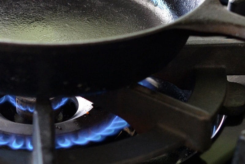 A cast iron skillet on top of a gas range.