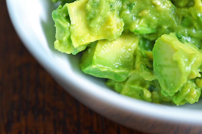 Cubes of avocado are mixed in with the mashed avocado.