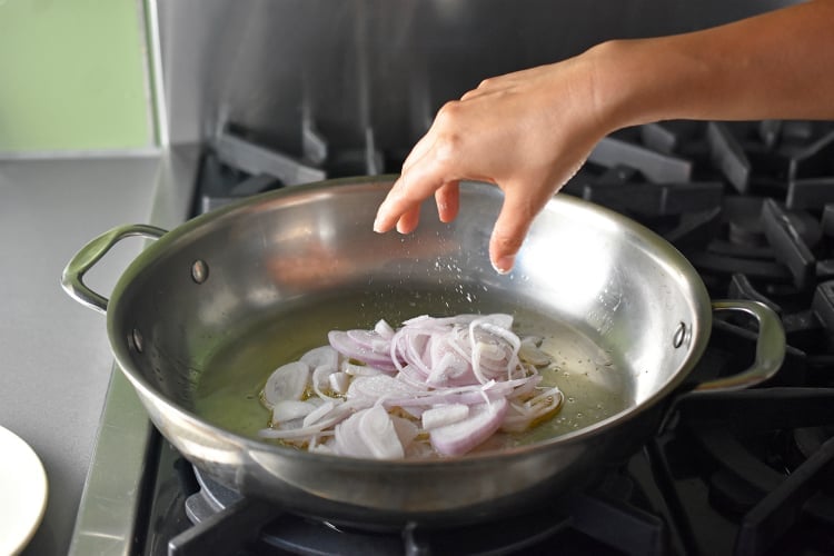 Sautéing some sliced shallots in a sauce pan