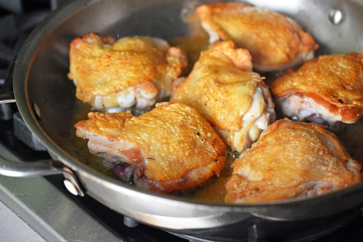 A closeup of a pan of Cantonese Crispy Chicken Thighs with crispy skin.