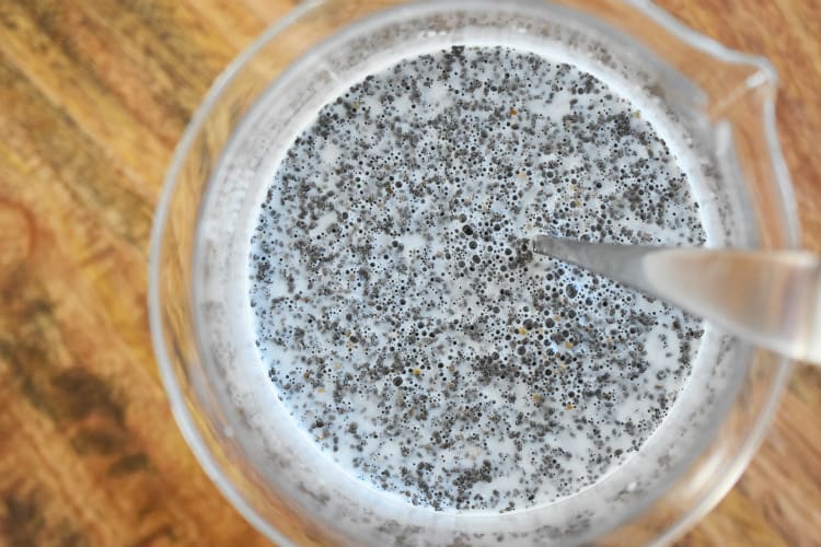 An overhead shot of the chia seeds mixed with the milk in a large measuring container.