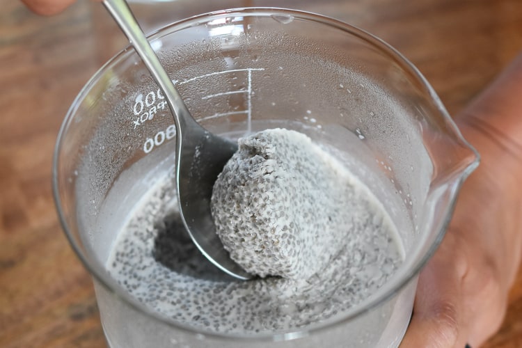 A spoon scooping out the cooled chia seed coconut milk mixture.