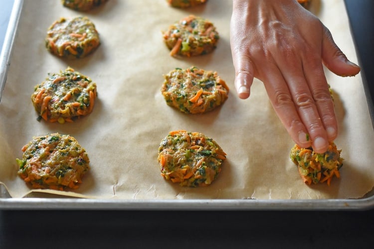 A hand is shown pressing down paleo Curry Turkey Bites into flat patties.