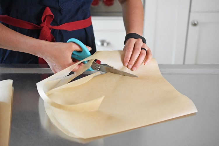 Someone cutting parchment paper.