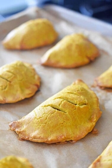 A closeup of Paleo Curried golden brown Meat Pies on a baking sheet.