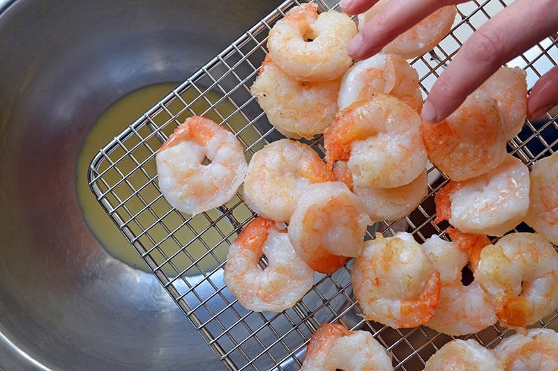 Adding the the fried shrimp to the dressing to make paleo walnut shrimp.