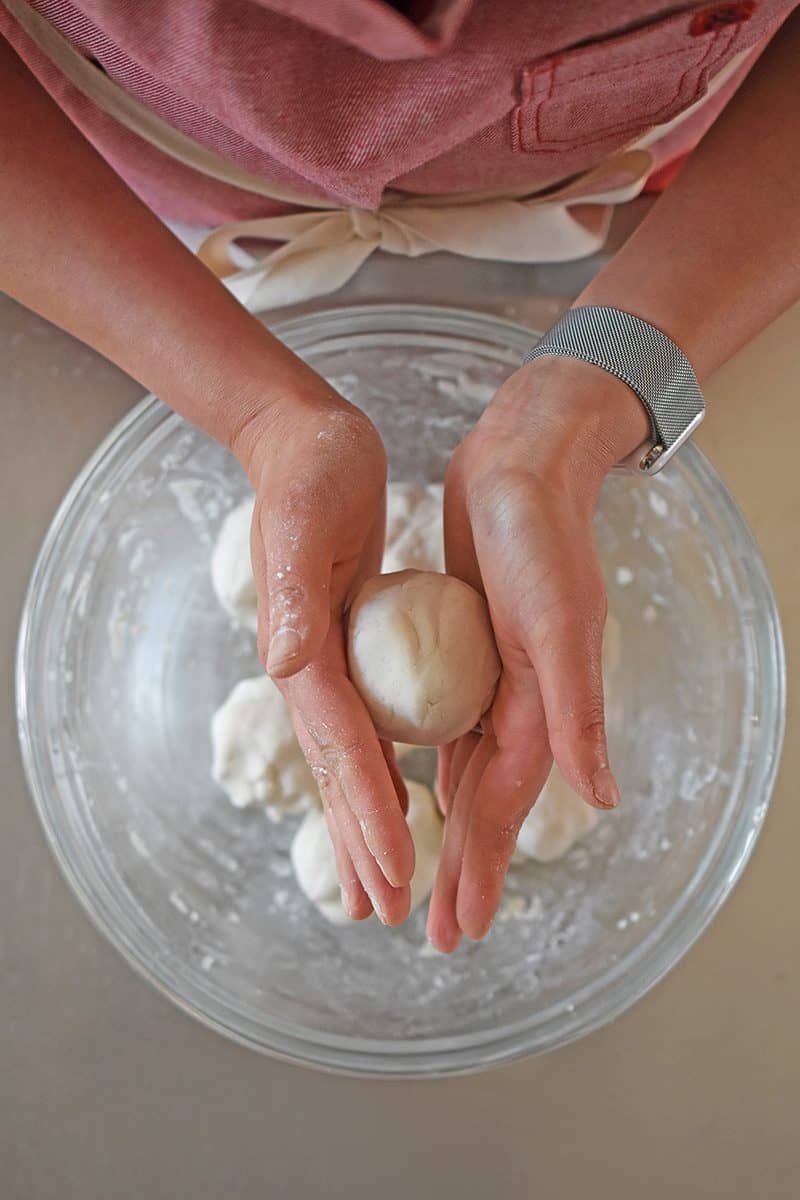 Rolling smaller balls of dough to make Paleo Scallion Pancakes 