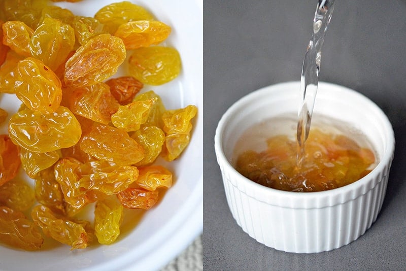 Golden raisins being soaked in a small bowl.