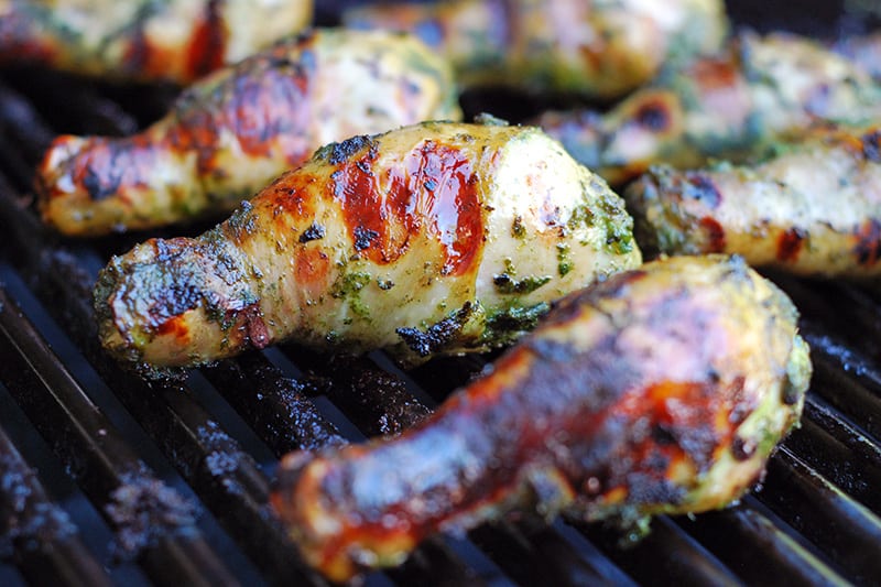 A closeup shot of My Sister’s Phenomenal Grilled Green Chicken on the grill.