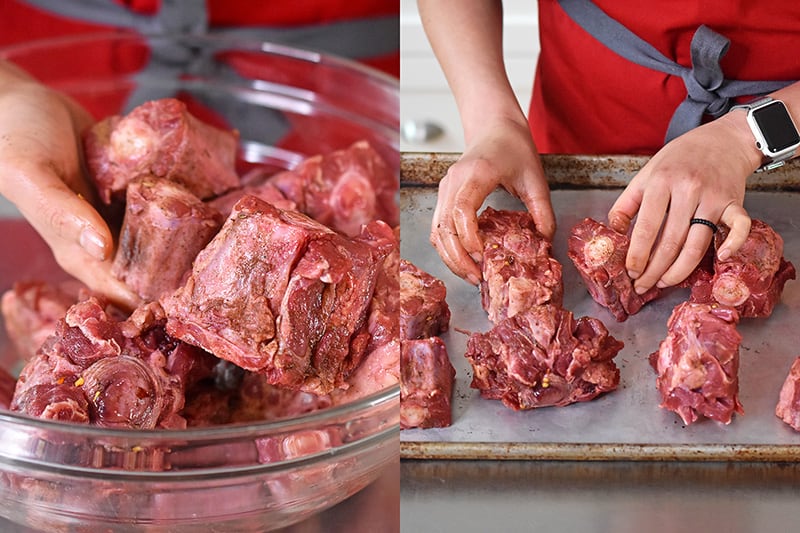 The oxtails are tossed by hand and then placed in a single layer on a rimmed baking sheet.
