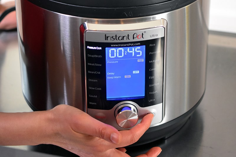 An Instant Pot Ultra display is pictured that is being programmed to cook for 45 minutes under high pressure.