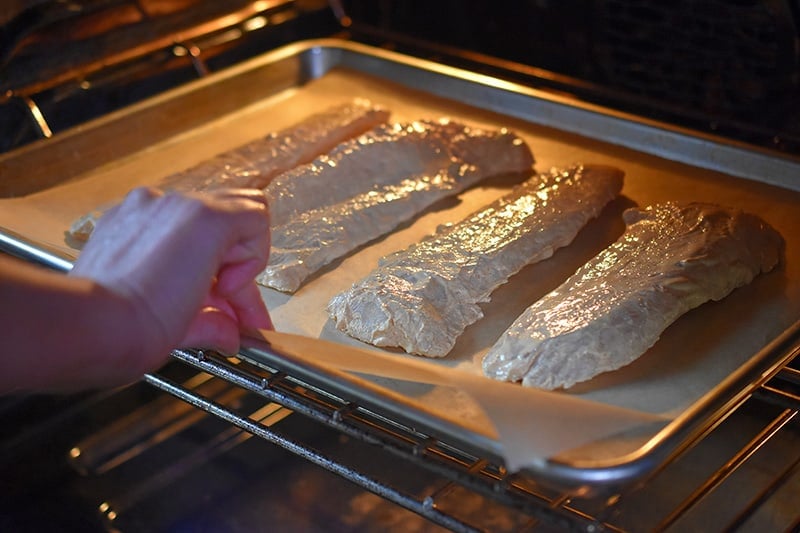 A tray of Tandoori Fish is placed in the oven.