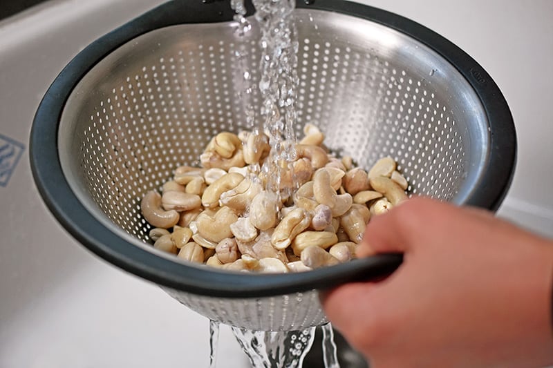 Rinsing soaked cashews to make vegan, No-Bake Matcha Cheesecake 