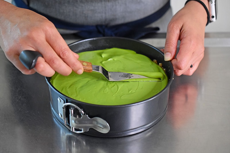 Smoothing the top of the vegan and paleo No-Bake Matcha Cheesecake with an offset spatula