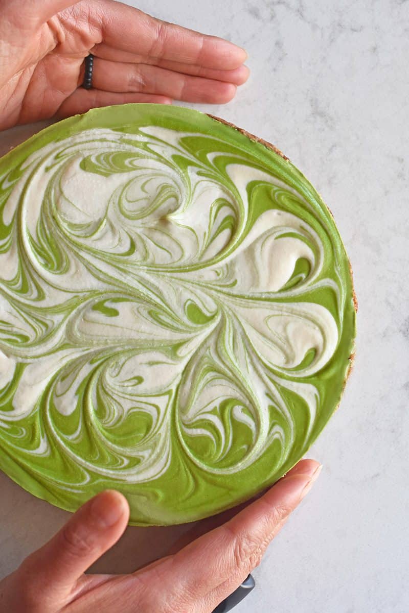 An overhead shot of healthy paleo No-Bake Matcha Cheesecake with a bright green and white swirled top!