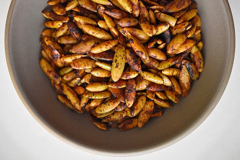 Baked pepitas cooling in a bowl.
