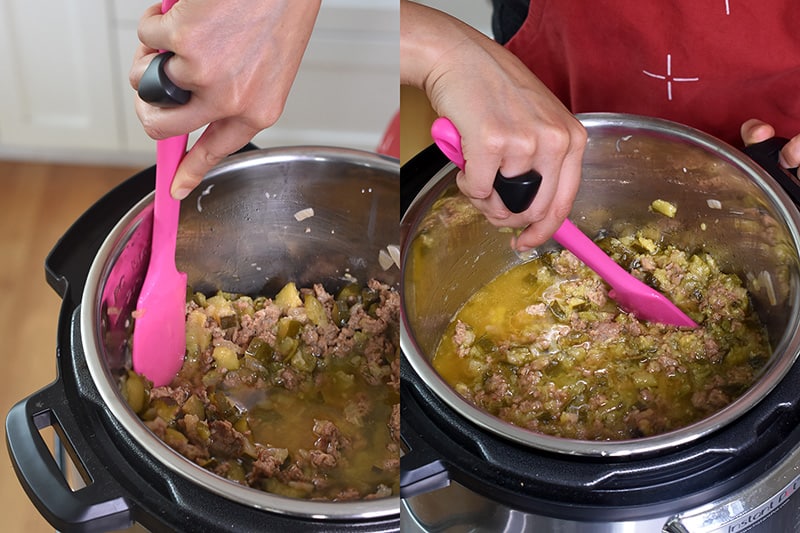 A pink silicone spatula is used to mash the cooked zucchini to make a sauce in an open Instant Pot.