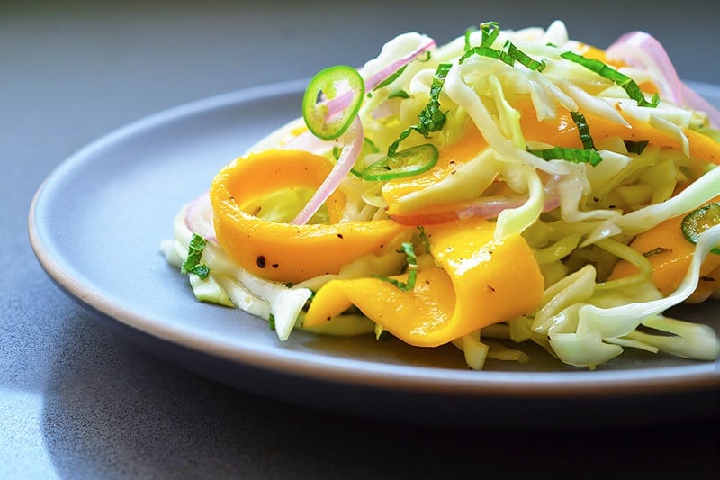 A pile of paleo spicy mango cabbage slaw on a plate.