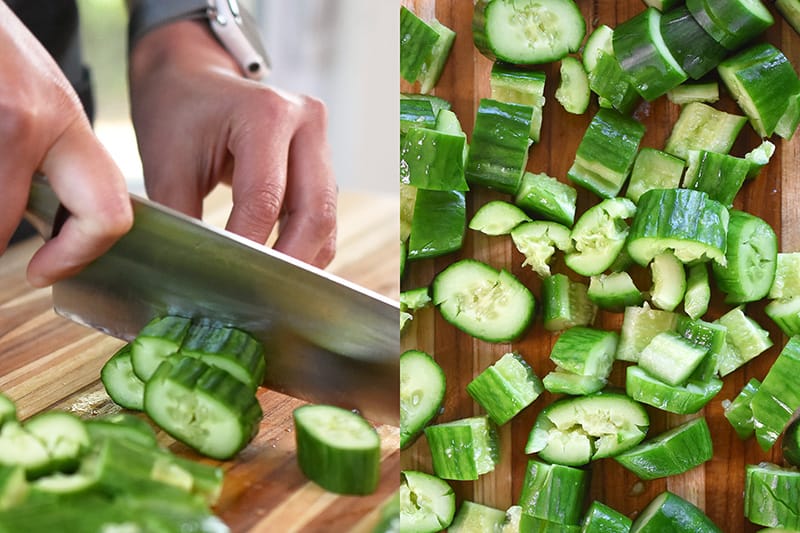 Chopping salt covered and smashed cucumbers into one inch pieces.