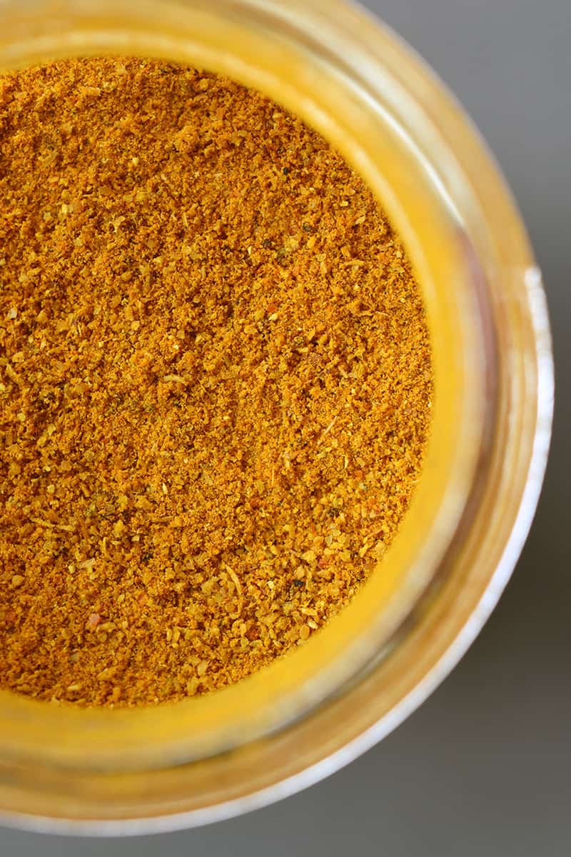 An overhead shot of an open jar of Indian curry powder.