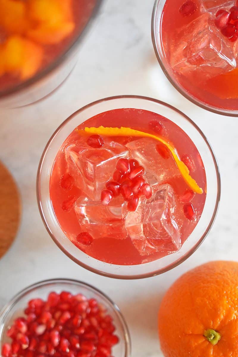 Overhead shot that shows a few glasses filled with Whole30-friendly Pomegranate Orange Mocktail