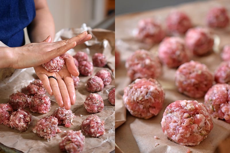 Two hands are rolling bulk sausage into meatballs.