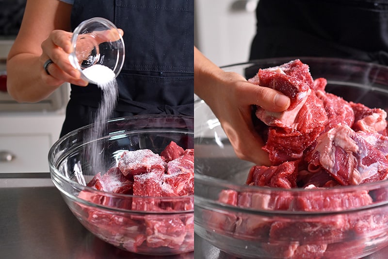 Cubes of beef chuck roast are seasoned and tossed with kosher salt.