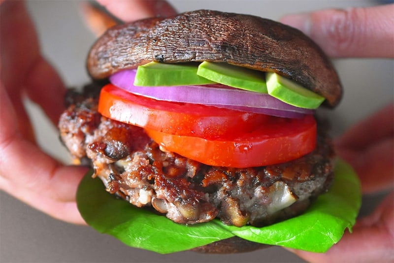 A shot of a burger with roasted portobello mushrooms as the bun.