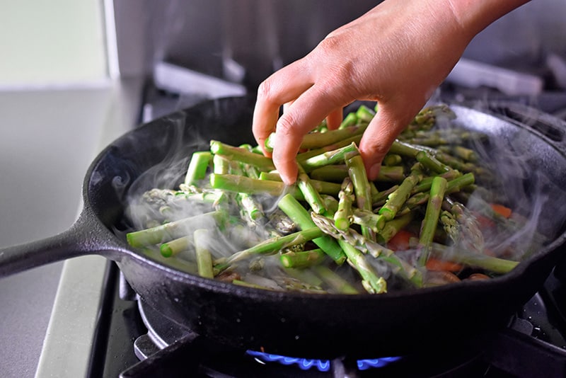 Photo of ingredients being placed in a hot skillet.