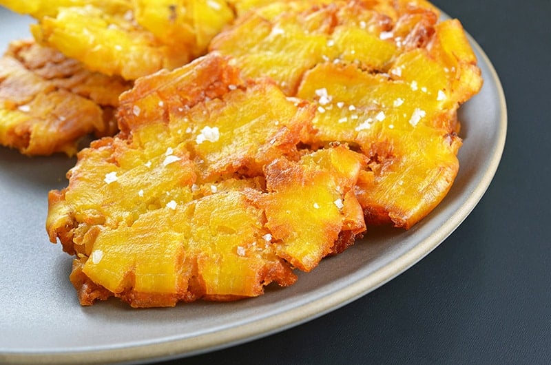 A closeup shot of a plate of fried green plantains (a.k.a. patacones or tostones).