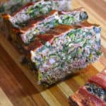 A closeup shot of sliced Easy Paleo Meatloaf on a wooden cutting board.