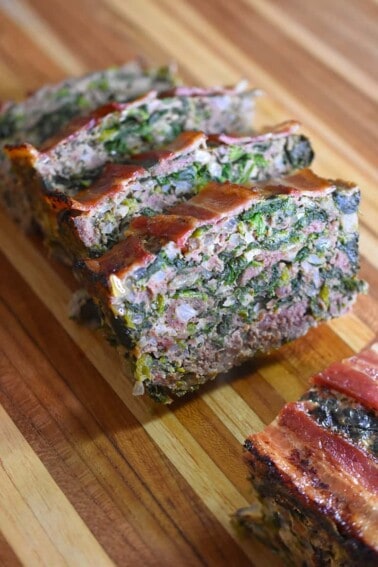 A closeup shot of sliced Easy Paleo Meatloaf on a wooden cutting board.