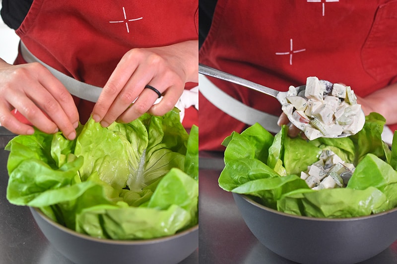 Lining a serving bowl with lettuce and scooping Chicken Waldorf Salad into the bowl.