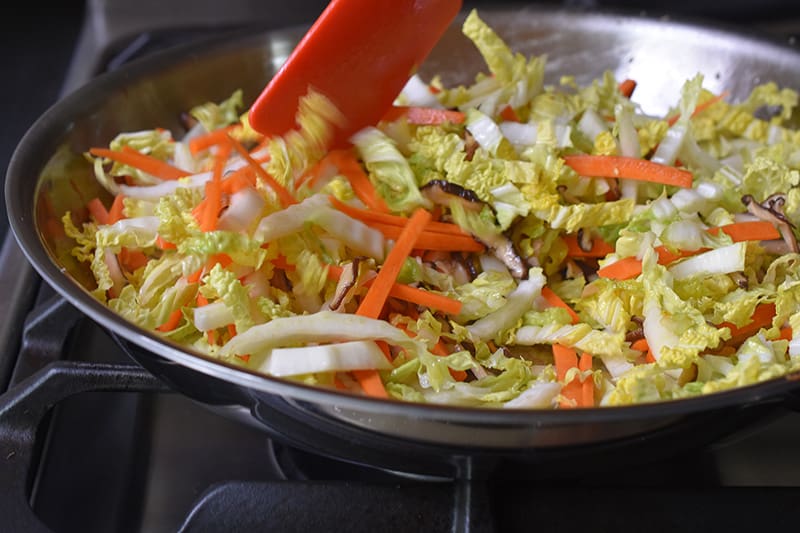 A side shot of the vegetables cooking in a large skillet.