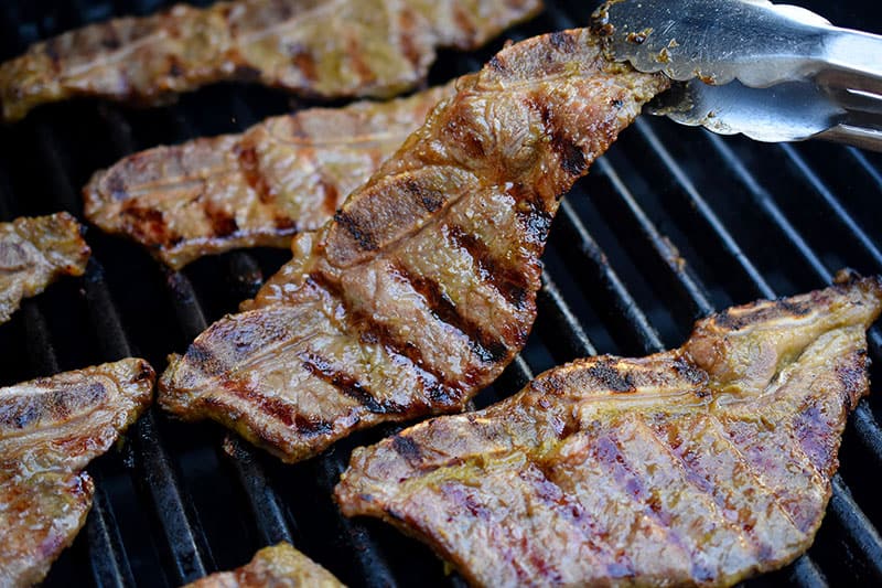 A closeup shot of paleo and whole30 kalbi cooking on the grill.