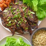 An overhead shot of paleo and Whole30 kalbi (Korean BBQ short ribs) served with Cauliflower rice, kimchi, and butter lettuce leaves.