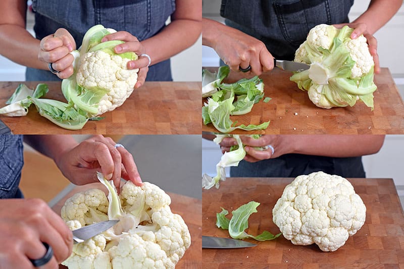 Someone preparing a whole cauliflower head to roast it in the oven.