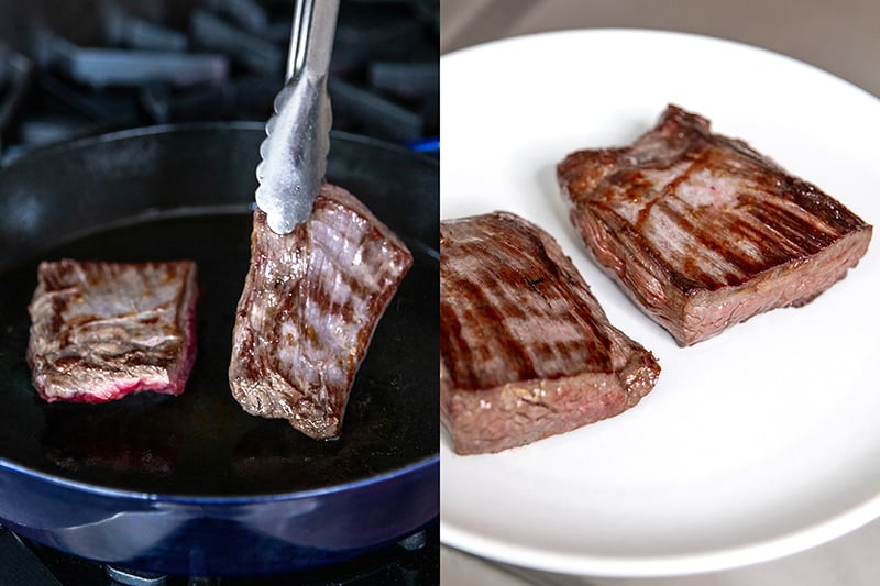 Searing two flank steaks in a cast iron skillet until browned on both sides. The steaks are transferred to a white plate to rest.