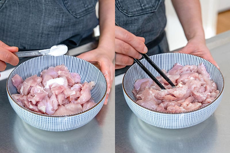 A person is adding arrowroot powder to sliced raw chicken thigh meat and stirring it with a pair of black chopsticks.