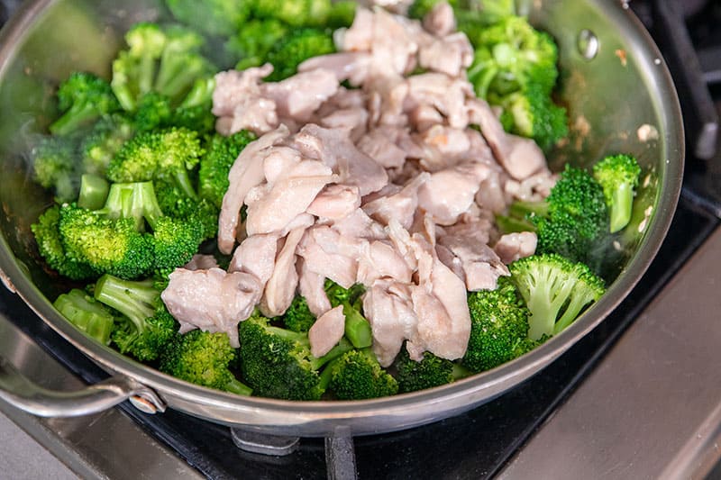 An overhead shot of a skillet filled with stir-fried broccoli and chicken.