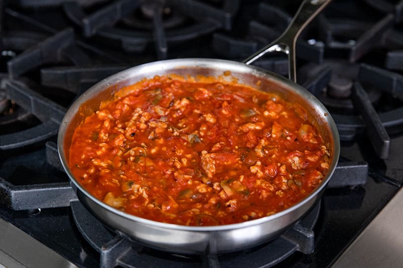 A skillet filled with spicy meat sauce for eggs in purgatory.