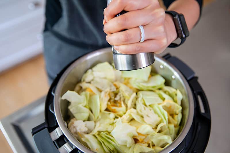 Adding the spices and seasoning to an Instant Pot to make Whole30 Atakilt wat, Ethiopian cabbage stew.