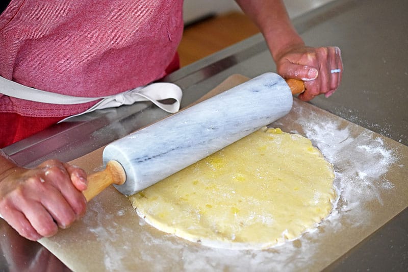 Rolling the gluten-free cherry galette dough with a marble rolling pin.