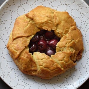 An overhead shot of paleo and gluten-free cherry galette on a white plate