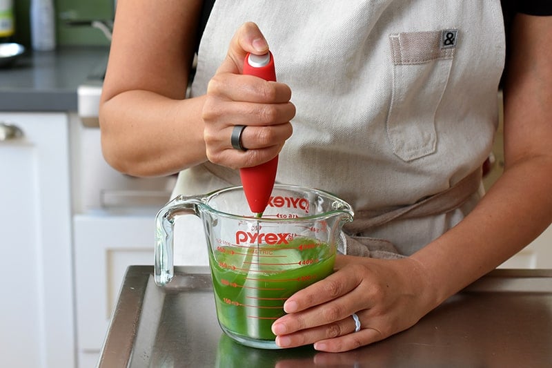Blending a matcha lemonade with a milk frother
