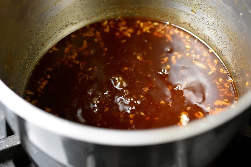 An overhead shot of simmering sauce in a small saucepan.
