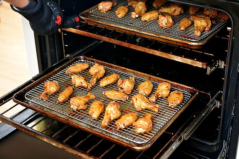 An open oven that shows the chicken wings are golden brown and ready to eat.