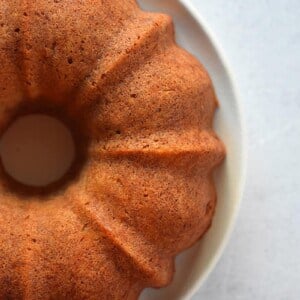 An overhead shot of 3/4 of an apple Bundt Cake on a white plate